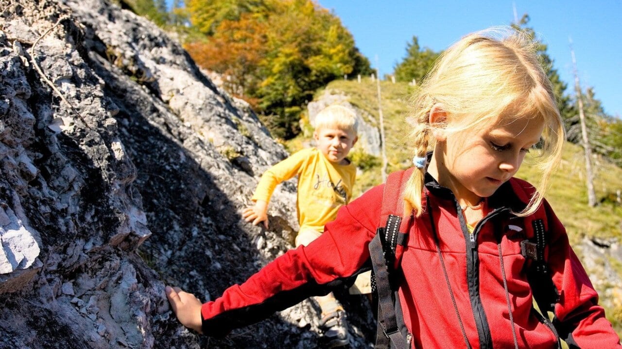 Kinder beim Klettern in der Natur.