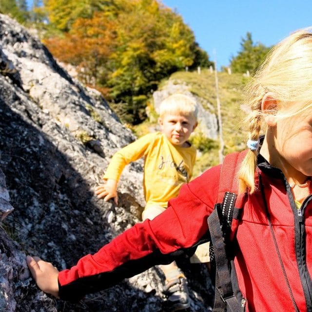 Kinder beim Klettern in der Natur.