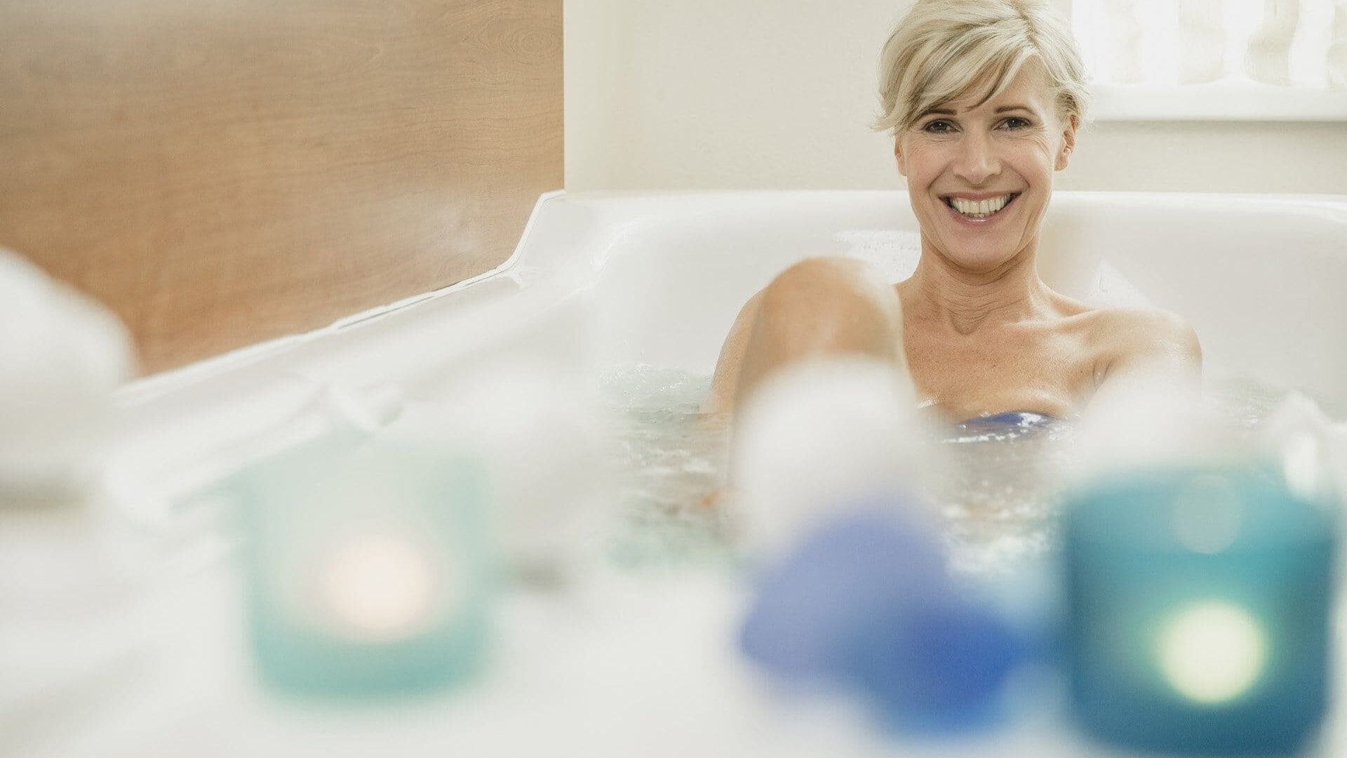 Frau entspannt in Badewanne mit Kerzen