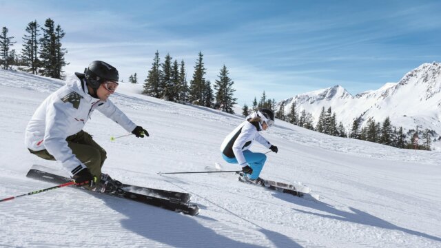 Two skiers navigating a snowy slope.