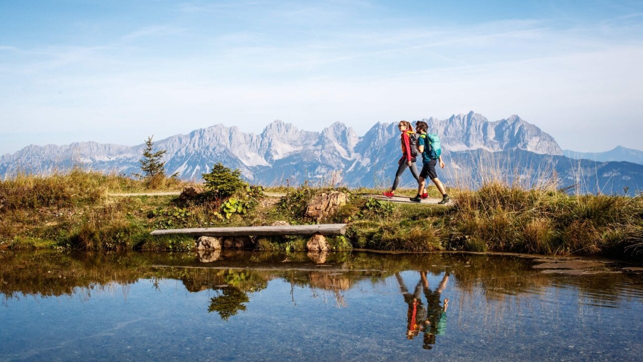 Wanderer am Bergsee mit Bergpanorama.