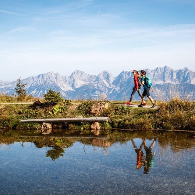 Wanderer am Bergsee mit Bergpanorama.