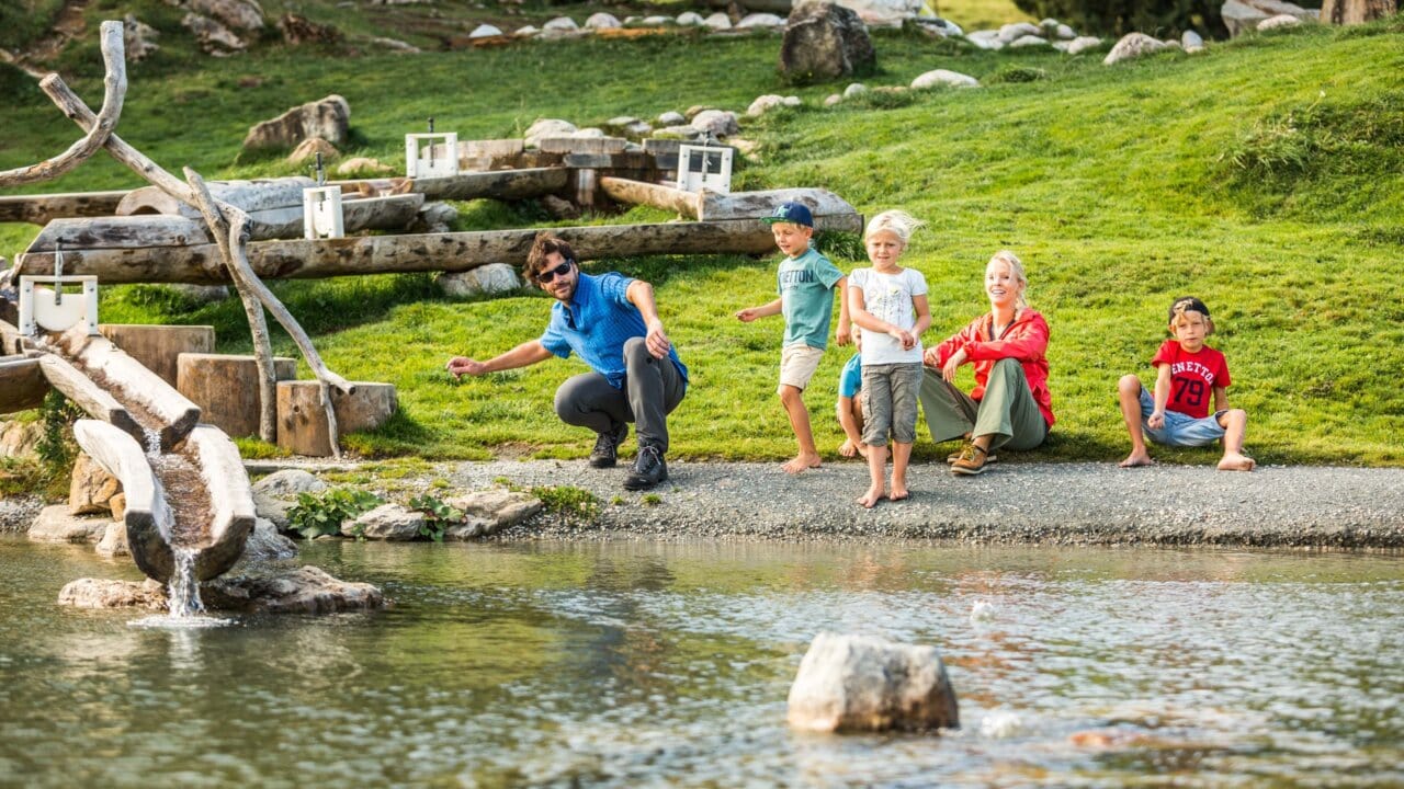 Familie spielt am Teich im Freien.
