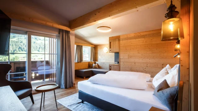 Gemütliches Hotelzimmer mit Holzdetails und Balkon.