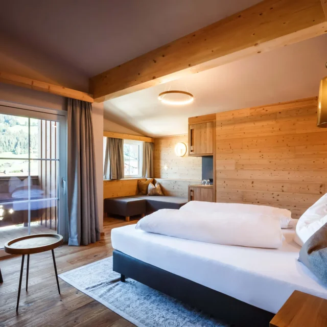 Gemütliches Hotelzimmer mit Holzdetails und Balkon.