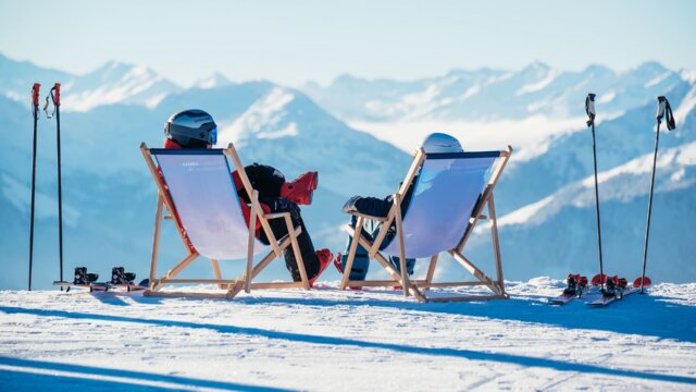 Skifahrer entspannen in Liegestühlen auf dem Berg