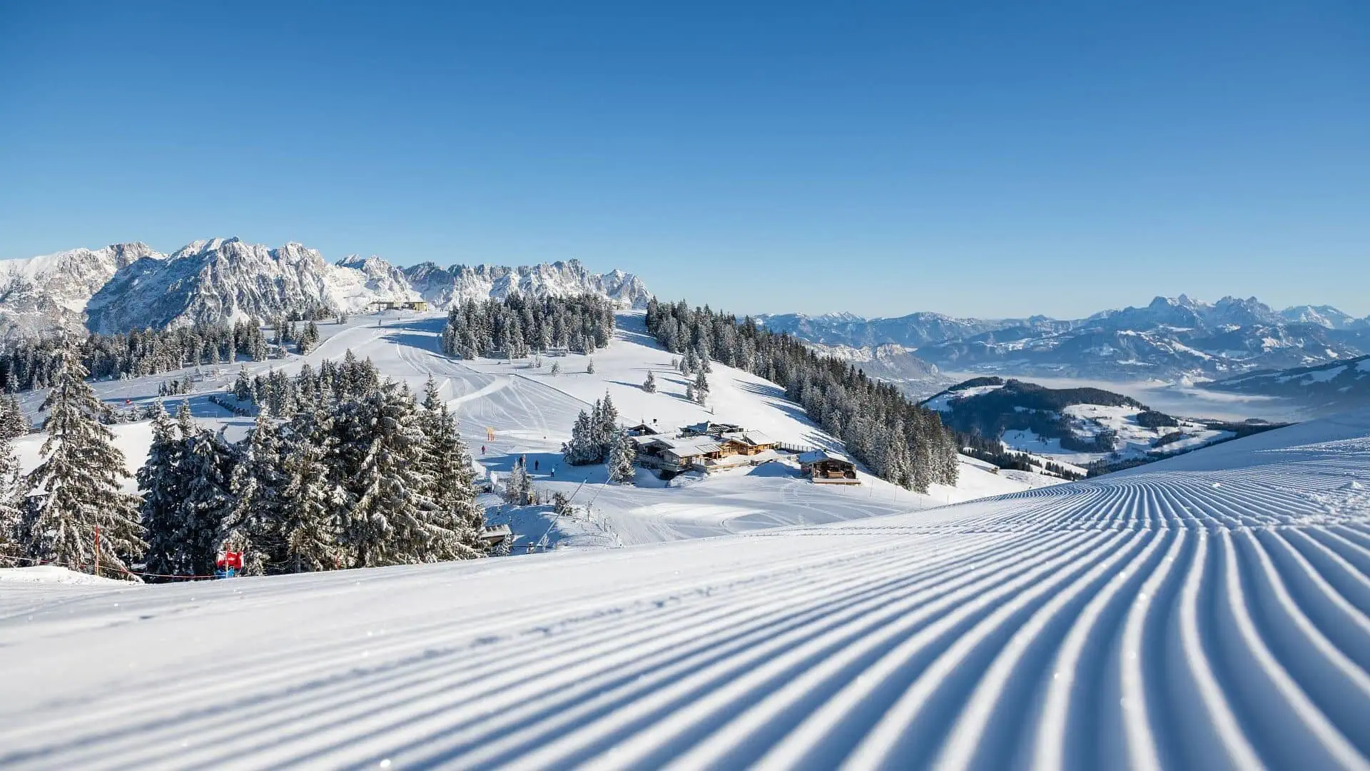 Schneebedeckte Berge und präparierte Pisten.
