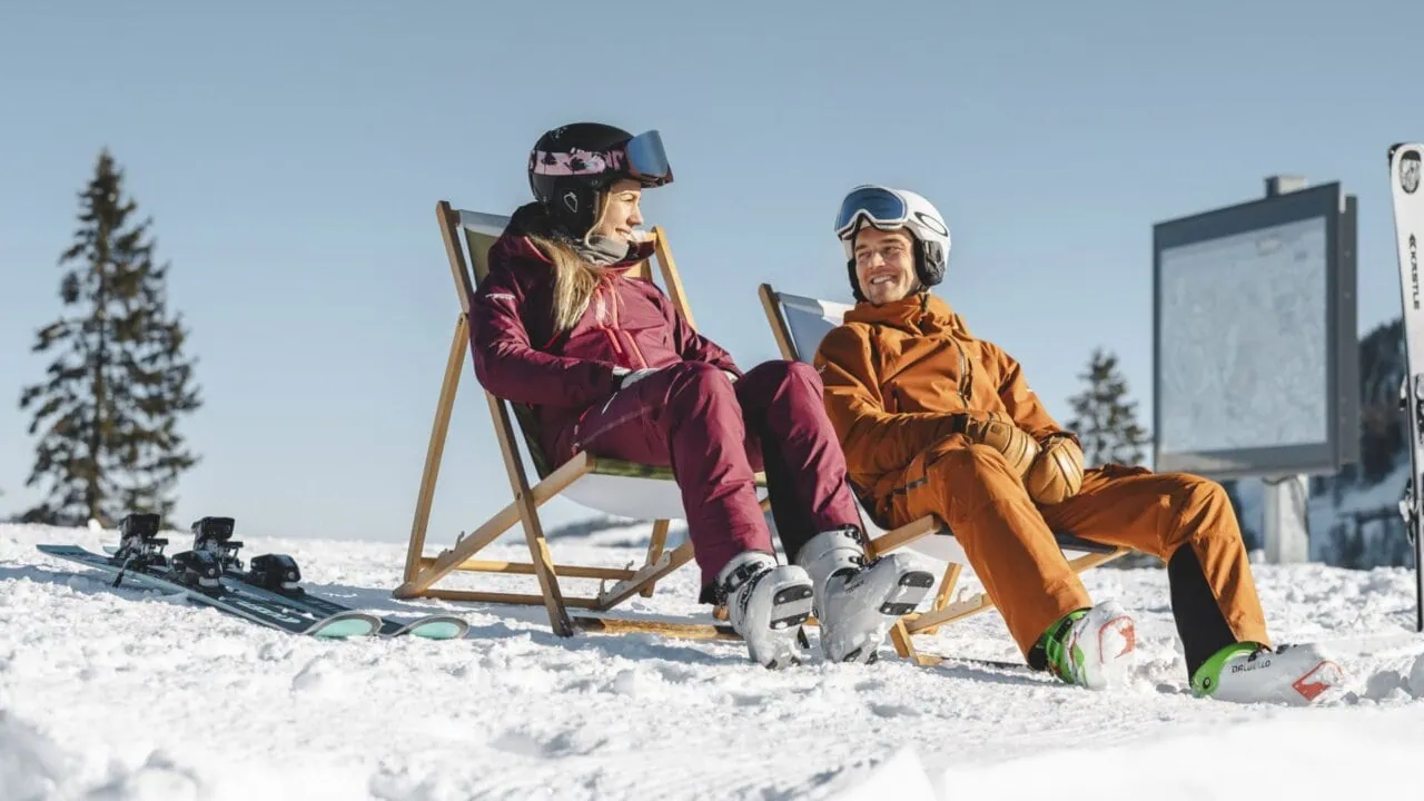Zwei Skifahrer entspannen im Schnee.