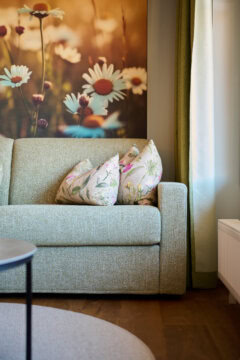 Gemütliches Sofa mit Blumenmustern und Naturblick