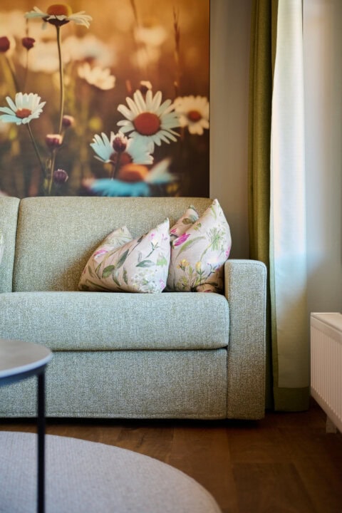 Gemütliches Sofa mit Blumenmustern und Naturblick