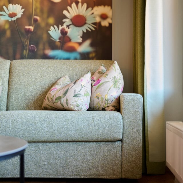 Gemütliches Sofa mit Blumenmustern und Naturblick