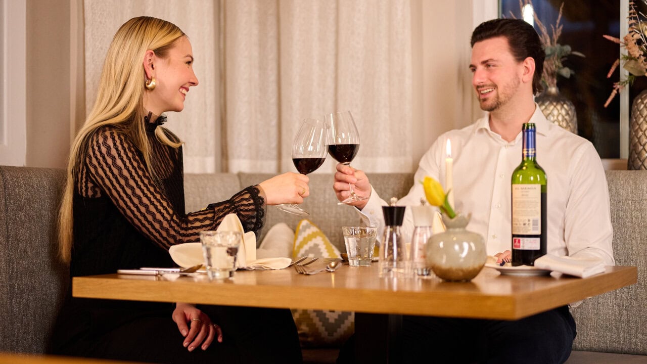 Paar stößt mit Rotwein an.