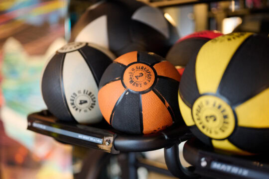 Verschiedene Medizinbälle auf einem Regal