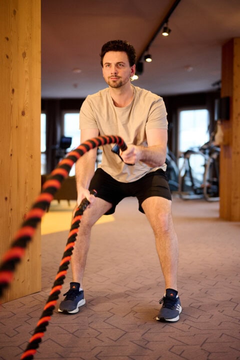 Mann trainiert mit einem Battle Rope im Fitnessstudio