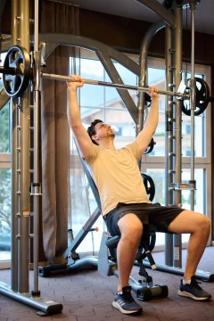 Mann trainiert mit Gewichten im Fitnessstudio.