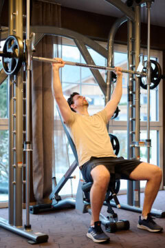 Mann trainiert mit Gewichten im Fitnessstudio.