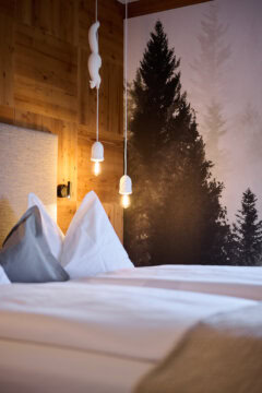 Gemütliches Schlafzimmer mit Holzvertäfelung und Beleuchtung.