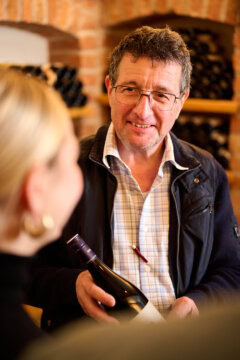 Mann zeigt Weinflasche in Weinbar