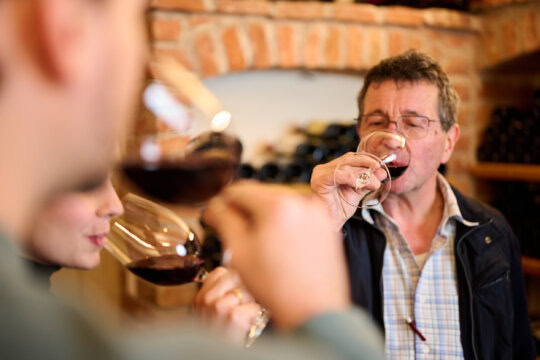 Menschen genießen Weinverkostung in einem Weinkeller.