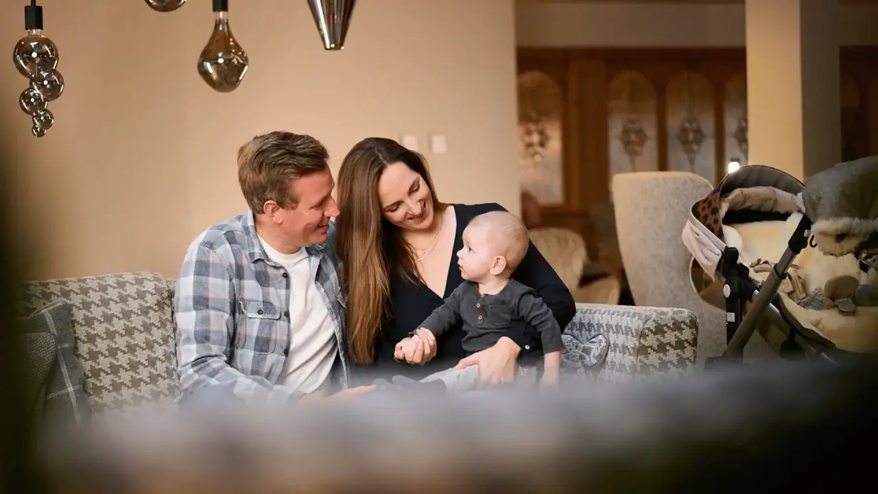 Familie spielt zusammen im gemütlichen Wohnzimmer.