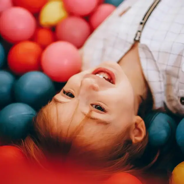 Kind spielt in bunten Bällen