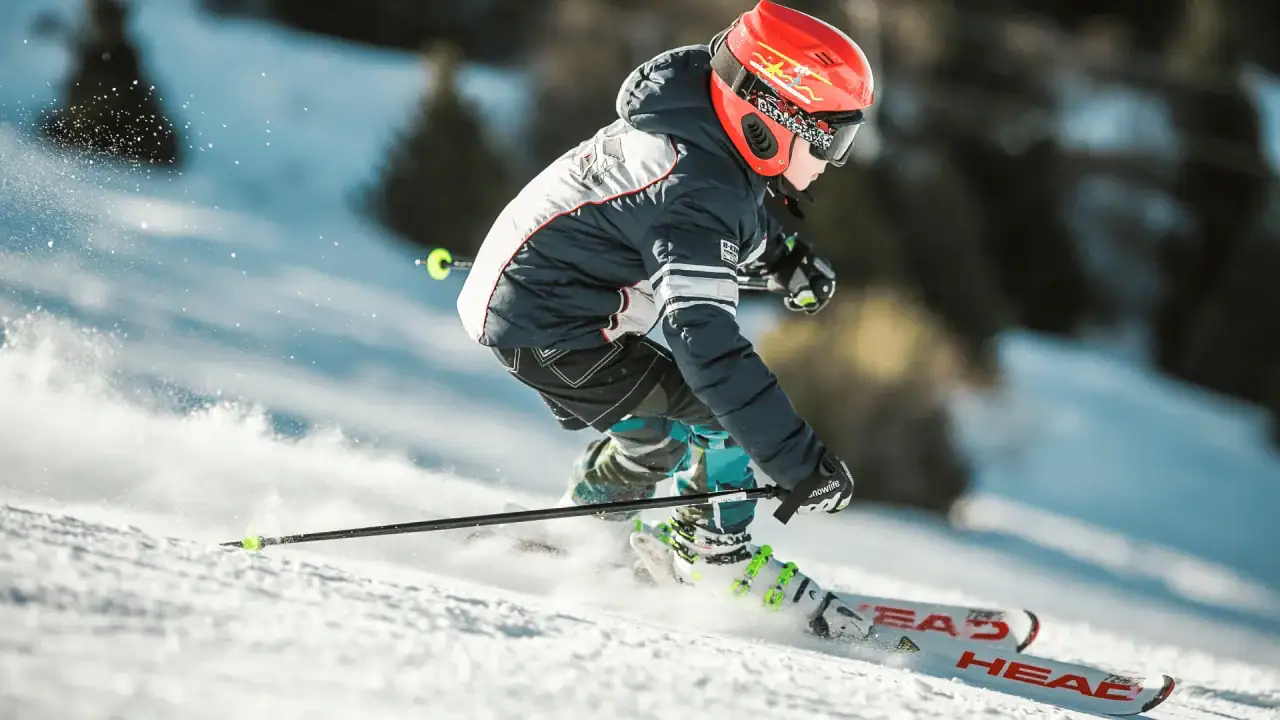 Kind fährt Ski auf verschneiter Piste.