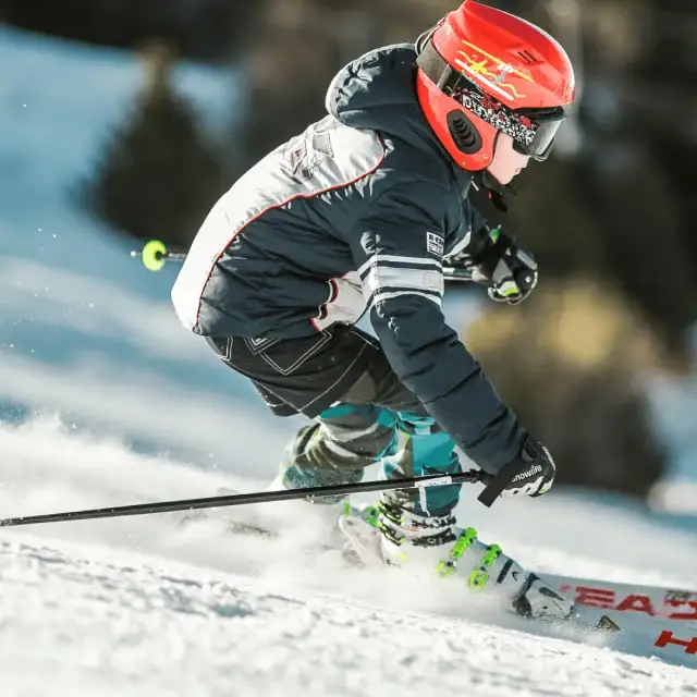 Kind fährt Ski auf verschneiter Piste.