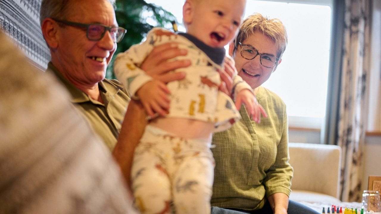 Spiele mit Großeltern und Enkelkind im Wohnzimmer.