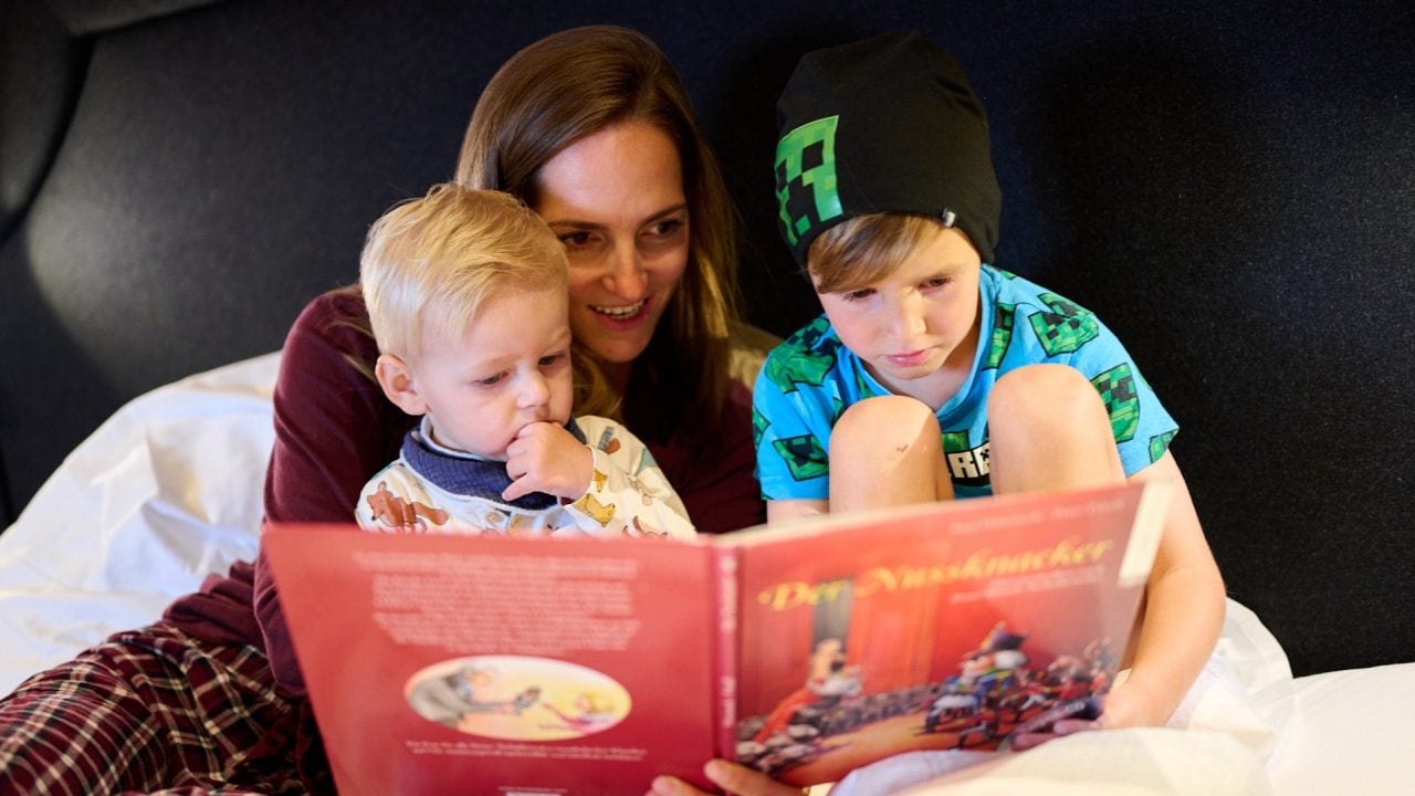 Familie liest gemeinsam ein Buch.