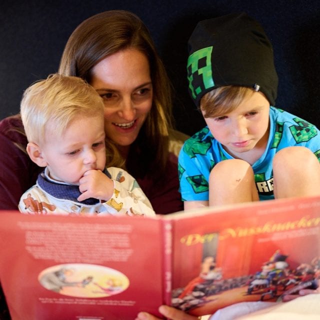 Familie liest gemeinsam ein Buch.