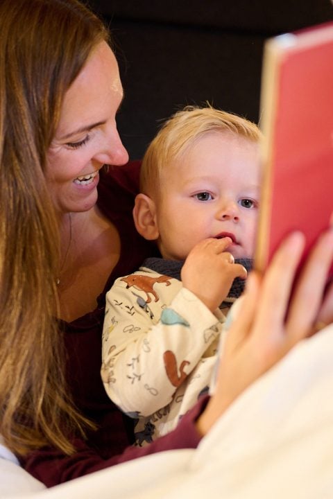 Mutter liest ihrem Kind ein Buch vor.