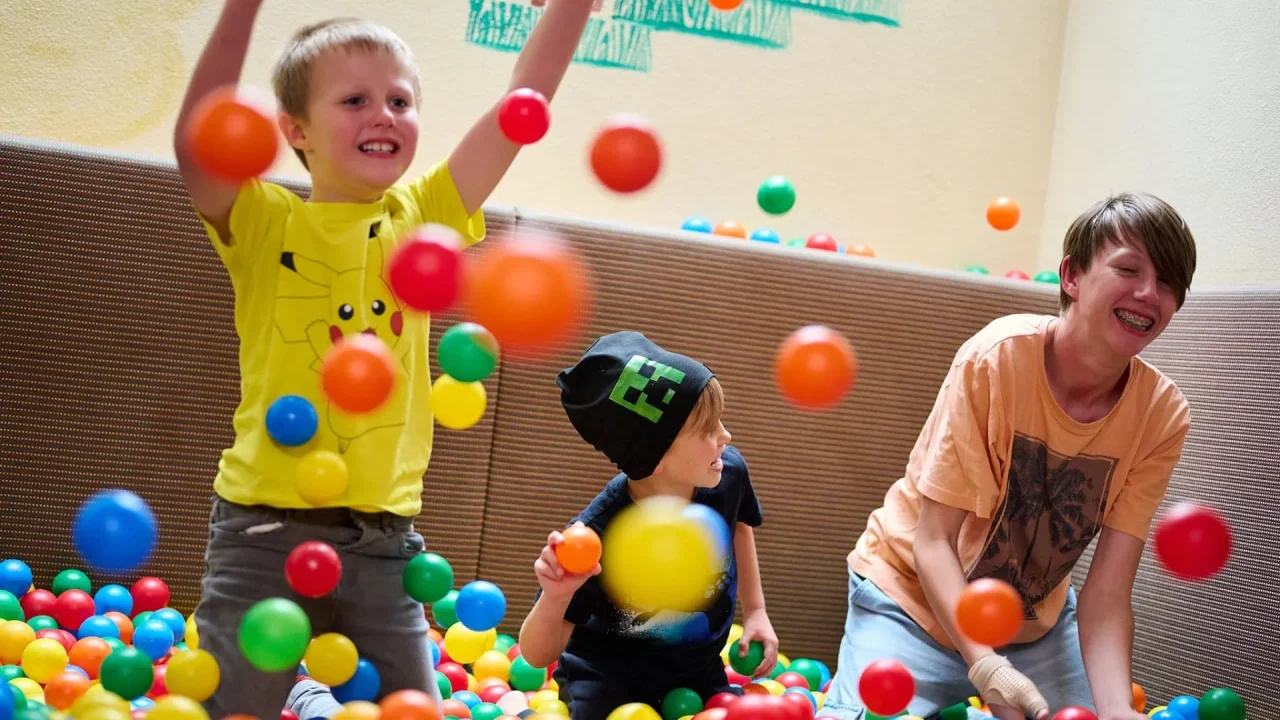 Kinder spielen mit bunten Bällen in einem Raum
