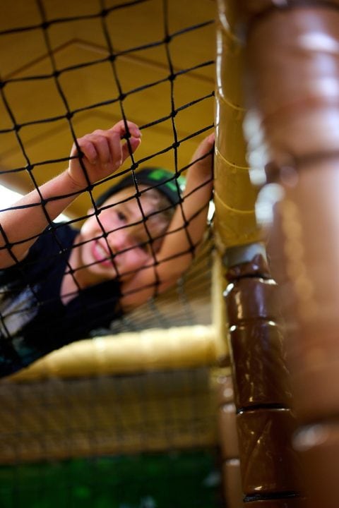 Kind spielt auf Klettergerüst mit Netz