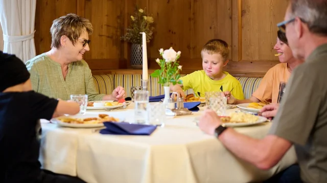 Familienessen am Tisch mit verschiedenen Gerichten.