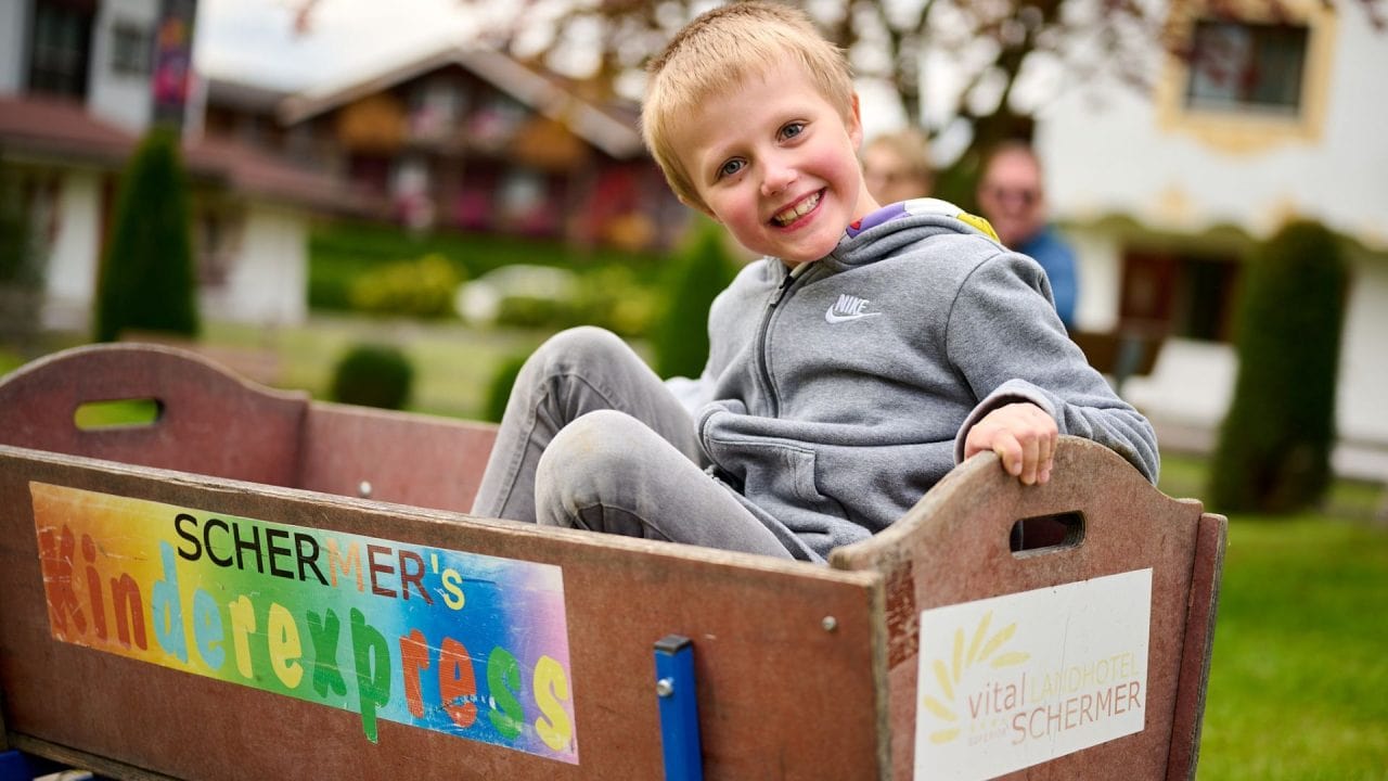 Junge fröhlich im Wagen im Freien