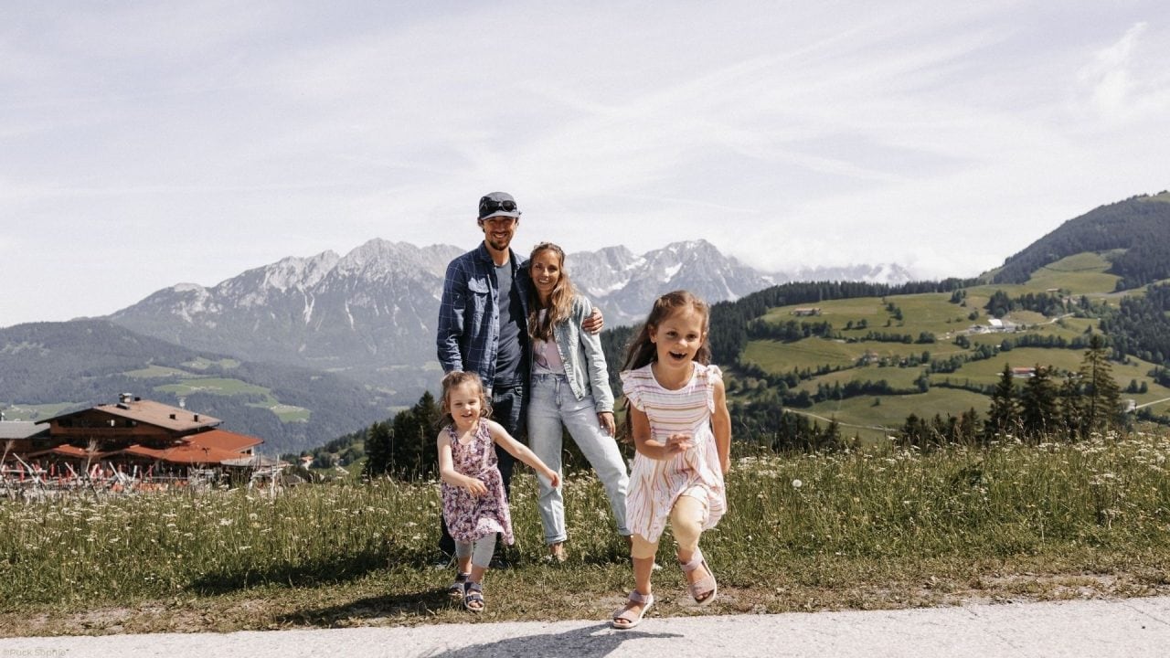 Familie in den Alpen mit Kindern im Vordergrund.
