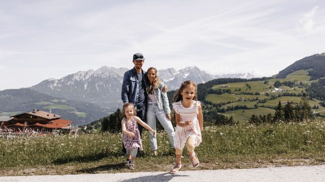 Familie in den Alpen mit Kindern im Vordergrund.