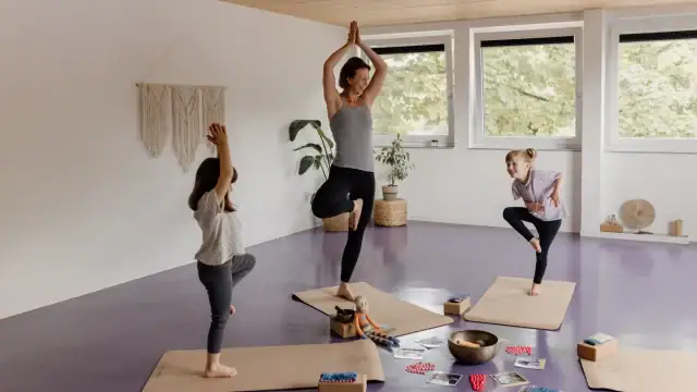 Yoga-Praxis mit Erwachsenen und Kindern im Raum.